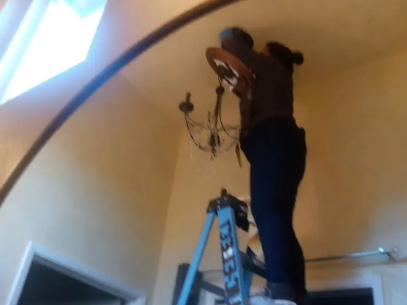 Electrician installing a chandelier in a Cottonwood residence